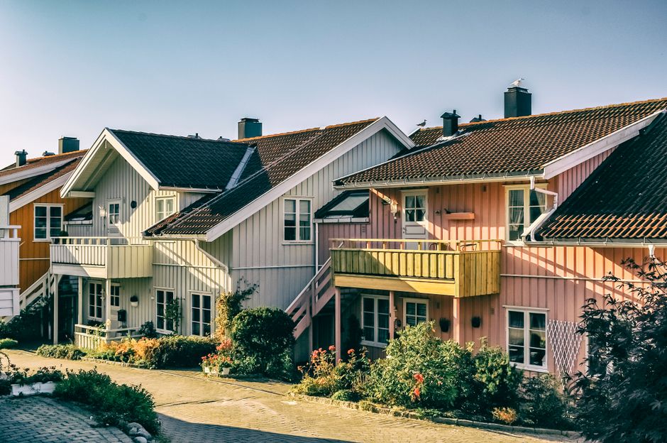 A clean, eye-level shot of a row of beautiful, modern homes under a clear blue sky, illustrating the scalable and structured nature of a real estate franchise.