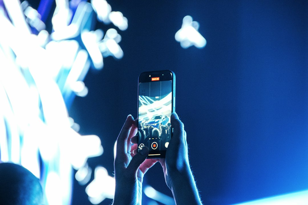 Traveler in a modern airport holds a smartphone displaying a glowing, futuristic interface, symbolizing the seamless integ...